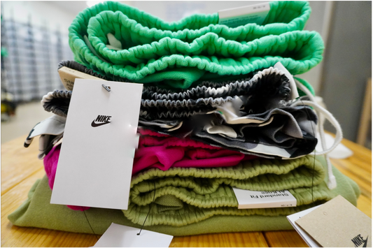Stack of folded clothes with visible Nike branding on a wooden surface
