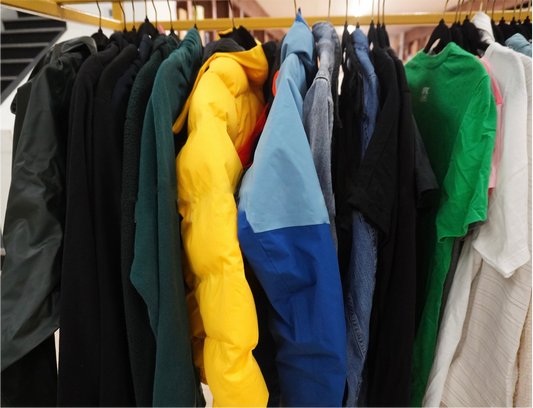 Clothing rack with various jackets in different colors hanging on it.